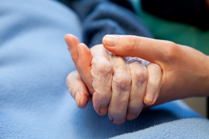 Elderly holding young hand